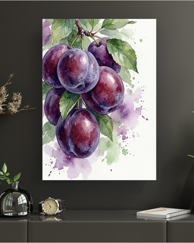Affiche murale verticale présentant une illustration aquarelle d'une grappe de six prunes violettes et juteuses, suspendues à une branche avec des feuilles vertes. Le fond est blanc avec des éclaboussures de peinture violette et verte, donnant un effet artistique et aérien. L'affiche est exposée sur un mur gris foncé, au-dessus d'une console sombre avec des éléments décoratifs.