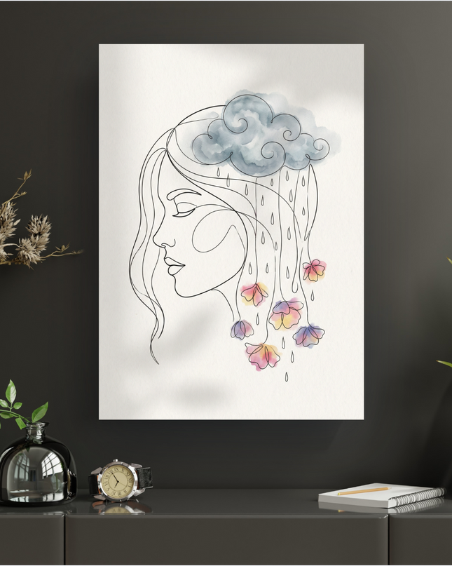 Affiche représentant un portrait de femme en line art, de profil, les yeux fermés. Au-dessus de sa tête, un nuage gris en aquarelle laisse tomber des gouttes qui se transforment en fleurs colorées aux teintes pastel (rose, jaune, violet, bleu) réalisées à l'aquarelle. Le fond de l'affiche est blanc. L'affiche est présentée sur un mur sombre, posée sur un meuble moderne avec des éléments de décoration végétale et une montre.