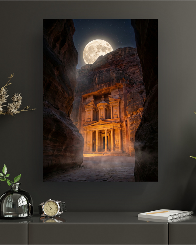 Affiche verticale représentant le monument antique du Khazneh (Le Trésor) à Petra, en Jordanie, éclairé par une lumière dorée sous une immense pleine lune et un ciel étoilé. Des falaises rocheuses sombres encadrent le temple, et une légère brume flotte au sol, créant une atmosphère mystérieuse et majestueuse.